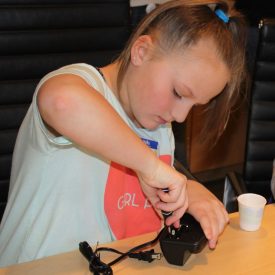 One of the Girl Scouts learns about reverse engineering by disassembling an alarm clock